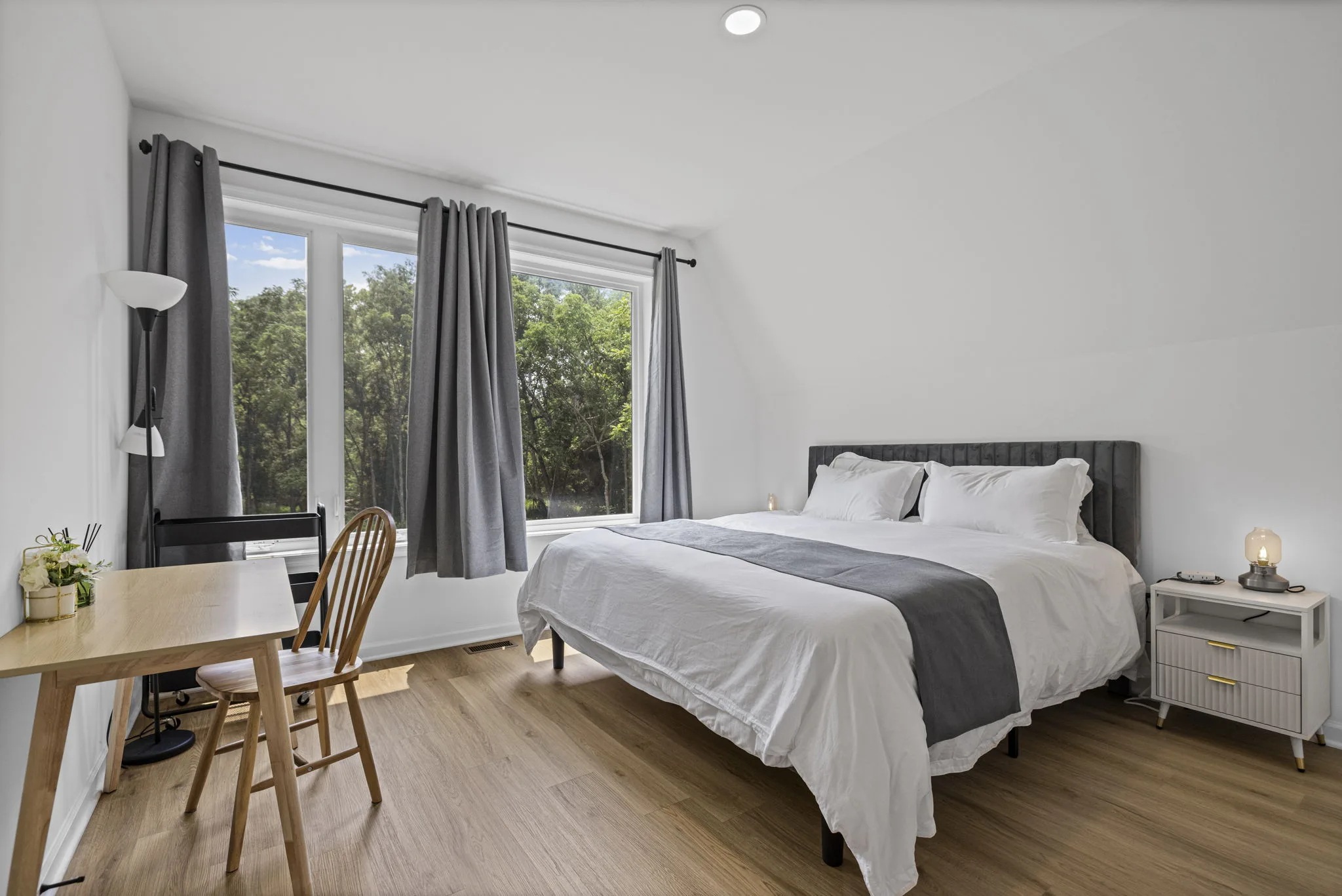 Guest bedroom with a dedicated workspace and woodland views