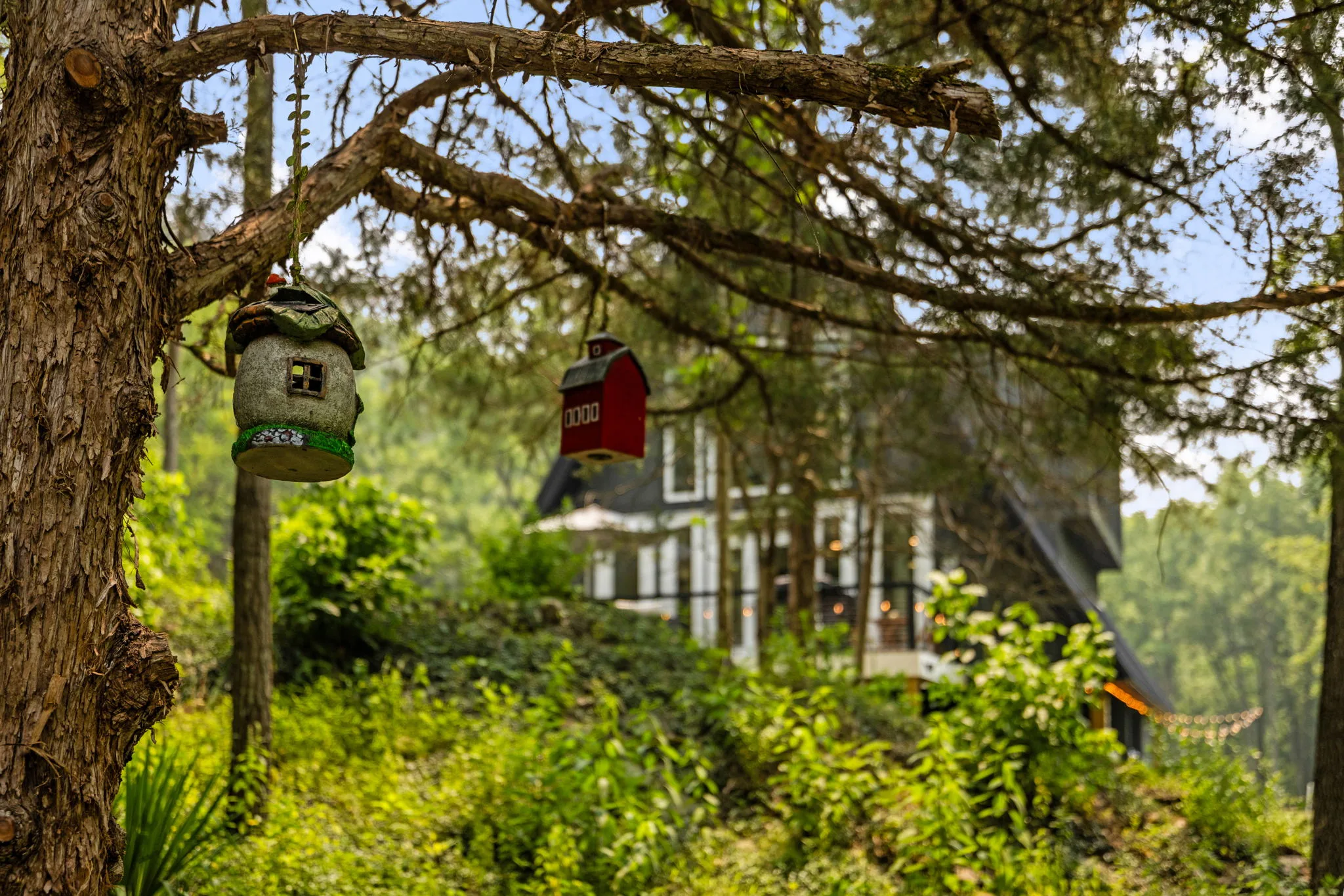 Garden ornaments hanging from a tree with the Chalet softly visible beyond