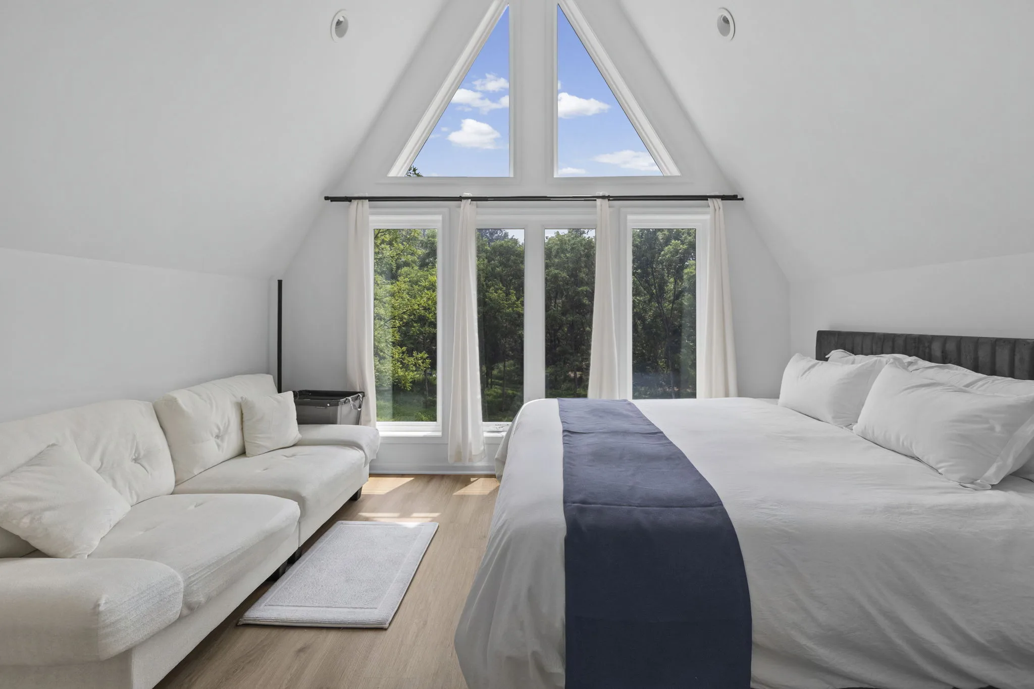 Primary bedroom beneath triangular A-frame windows